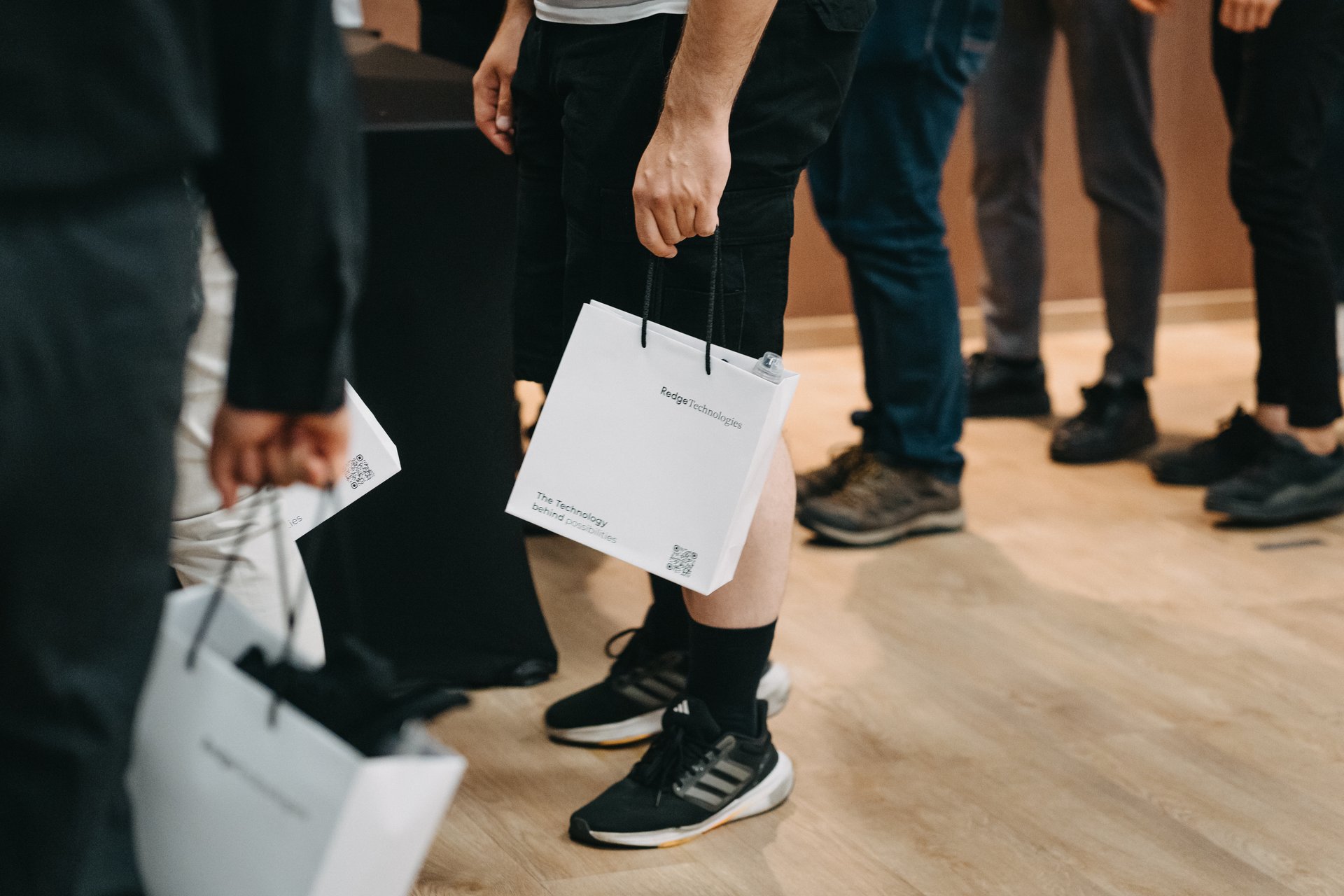 Uczestnik odbiera torbę powitalną przy wejściu na event firmowy