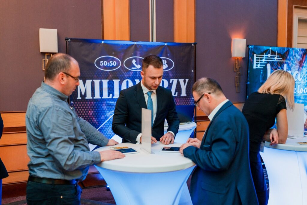 Uczestnicy przy stanowisku Milionerzy odpowiadają na pytania podczas gali