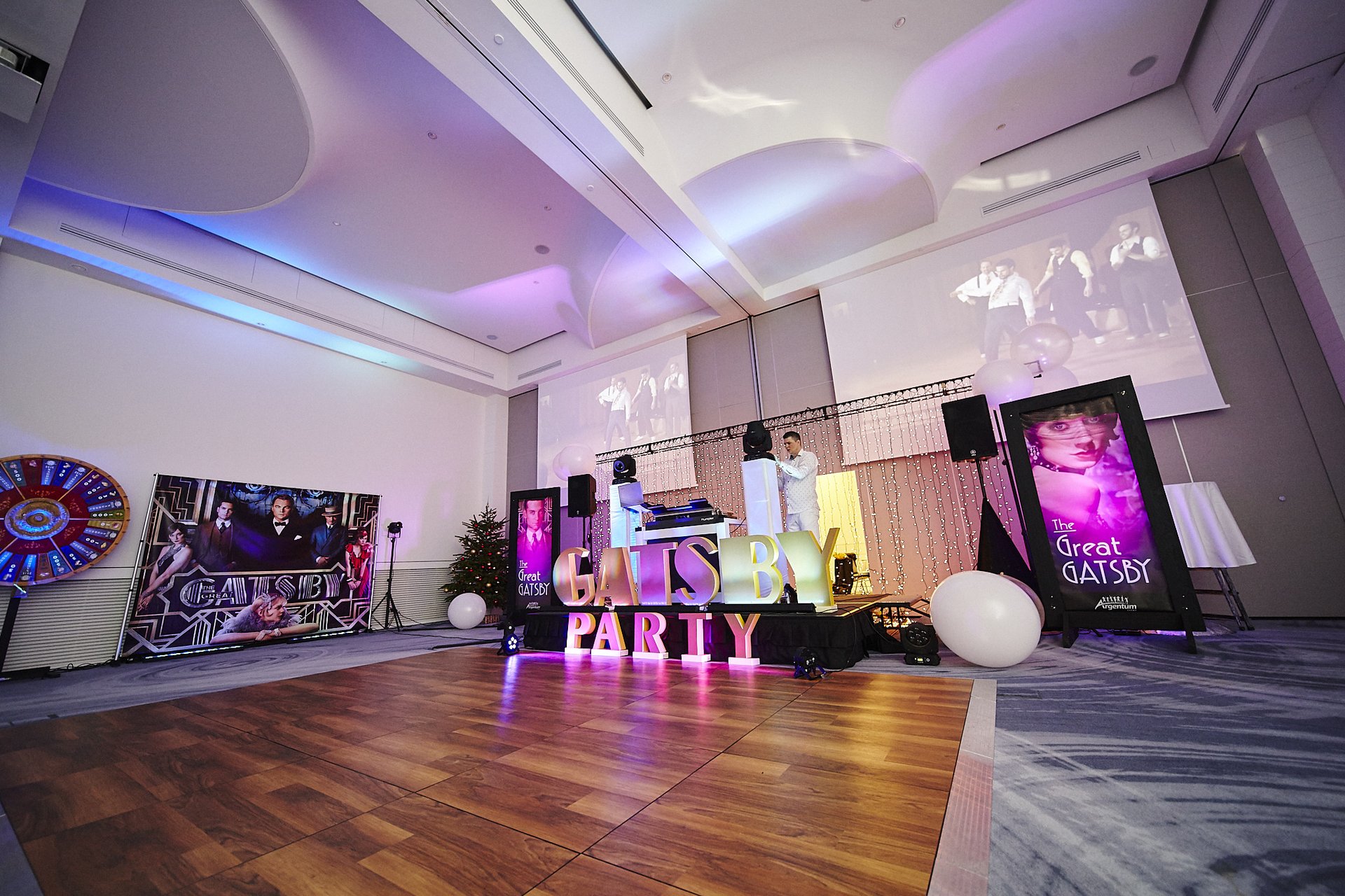 Sala balowa w kompleksie OVO z neonowym napisem GATSBY PARTY i ekranami z Wielkim Gatsbym